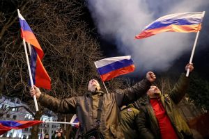 Russian public celebrating after Putin speech in Feb, waving Russian flags.