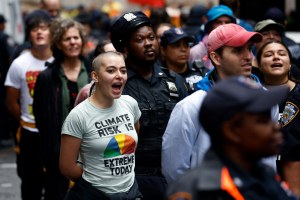 A climate activist continues to chant while under arrest