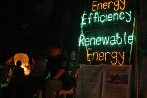 Members of Greenpeace put up a neon sign powered by solar energy