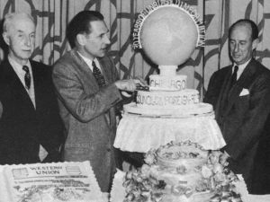 Six men stand around a cake for the Council's 30th anniversary