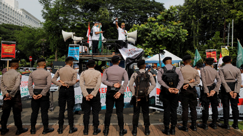 As police officers watch, Indonesian palm oil farmers protest the government's palm oil export ban outside the Coordinating Ministry of Economic Affairs office in Jakarta, Indonesia.