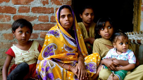 Shyamkali sits on the ground, surrounded by four of her six daughters.