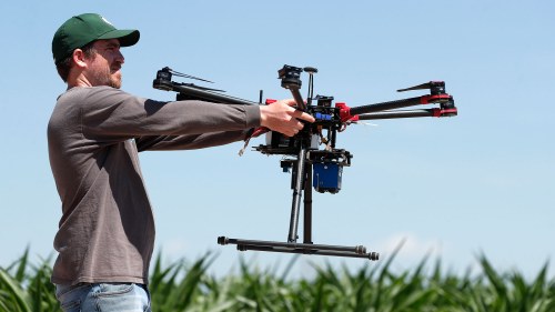 A USDA intern prepares to place a drone at a research farm. Researchers are using drones carrying imaging cameras over the fields in conjunction with stationary sensors connected to the internet to chart the growth of crops in an effort to integrate new technology into farming. 