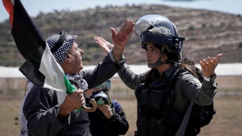 A Palestinian protester argues with Israeli security forces to prevent shooting tear gas at Palestinian protesters during a demonstration against Israeli settlements in the village of Qaryout, near the West Bank city of Nablus, Friday, Sept. 15, 2023. 