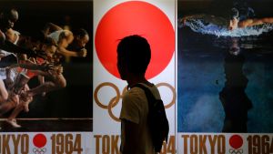 A pedestrian looks at pictures of the 1964 Summer Olympics in Tokyo