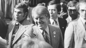 Jimmy Carter shakes people's hands in a crowd