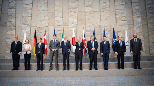 G7 Meeting in Brussels in front of flags and a brick wall.