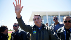 Jair Bolsonaro waves in sunlight. 