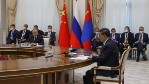 Chinese President Xi Jinping and Russian President Vladimir Putin sit together in a meeting.