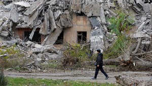 A man walks past the ruins of a destroyed building in Mariupol