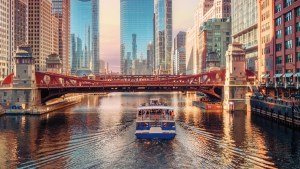 A boat floats down the Chicago River on a clear day