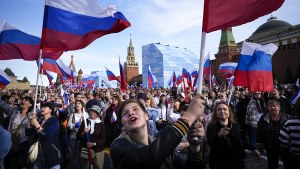 Thousands of people wave Russian national flags as they gather on Red Square 
