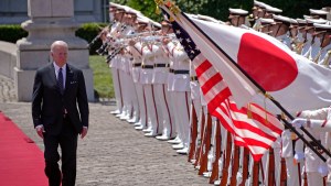 Biden walks by a Japanese flag