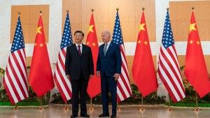 Xi Jinping and Joe Biden stand in front of Chinese and American flags
