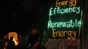 Members of Greenpeace put up a neon sign powered by solar energy