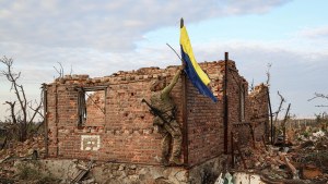 A Ukrainian military commander raises the Ukrainian flag as a symbol of liberation of the frontline village of Andriivka