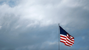 An American flag flies in a cloudy sky