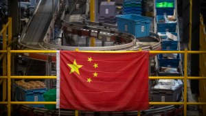 a Chinese flag hangs near an automated parcel handling line at a warehouse for an online retailer in Beijing